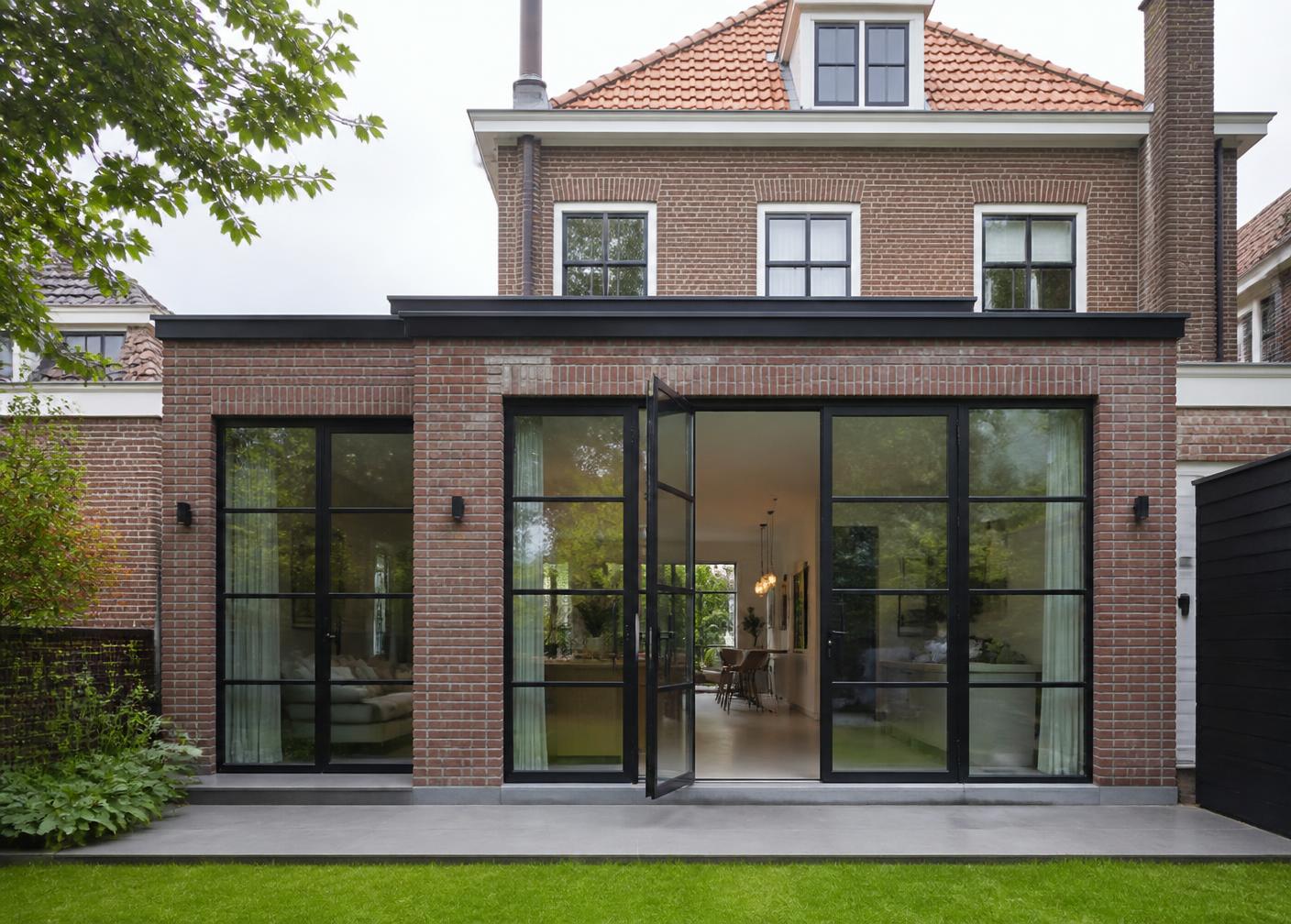 Moderne uitbouw aan een Nederlandse woning met stalen taatsdeuren